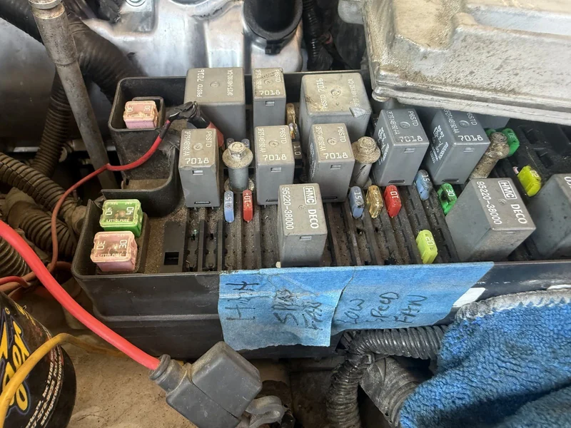 A relay box open, with the tech's own notes taped beside it.